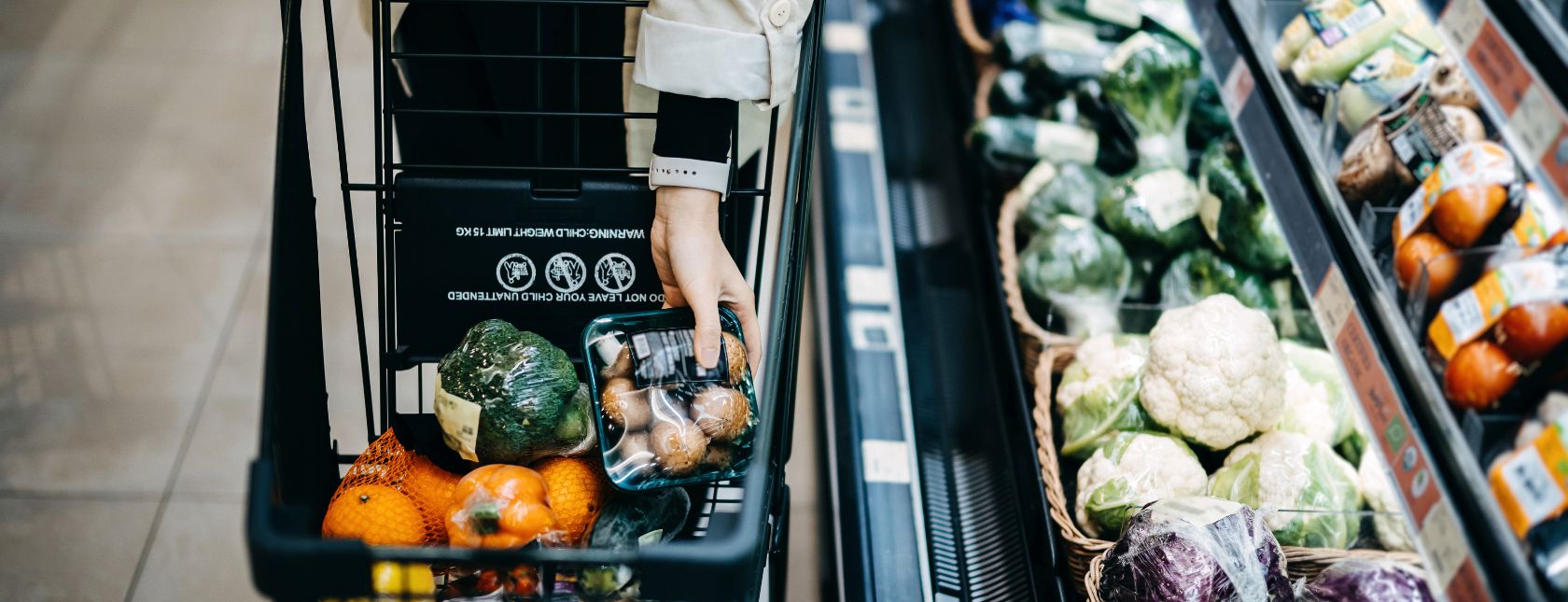Close up of woman's hand shopping for fresh groceries in supermarket