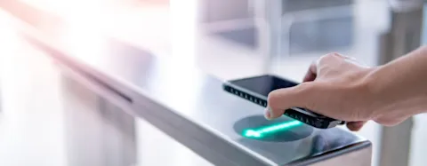 Male hand using smartphone to open automatic gat