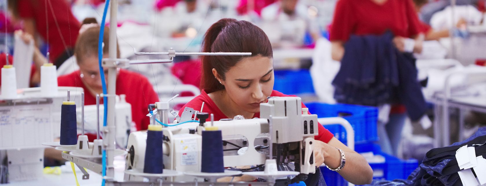 Young seamstress working in a cloth factory